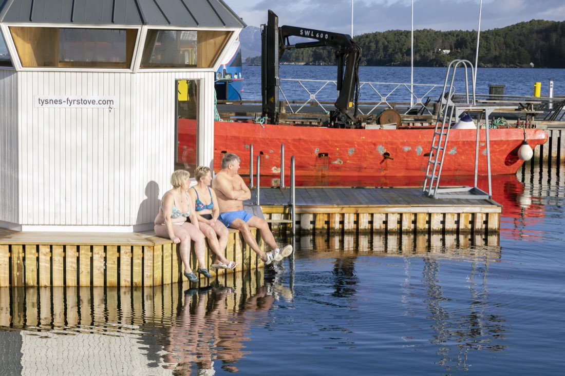 Guests on the jetty edge by the sauna on a summer evening